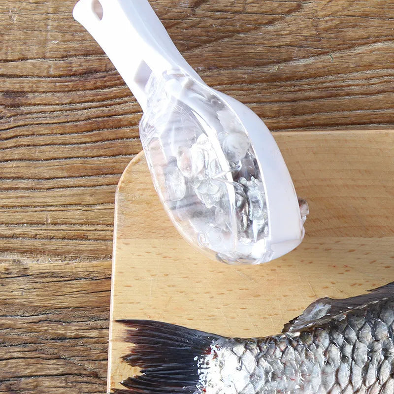 White fish-shaped kitchen scaler tool with a cover and hanging hole on handle