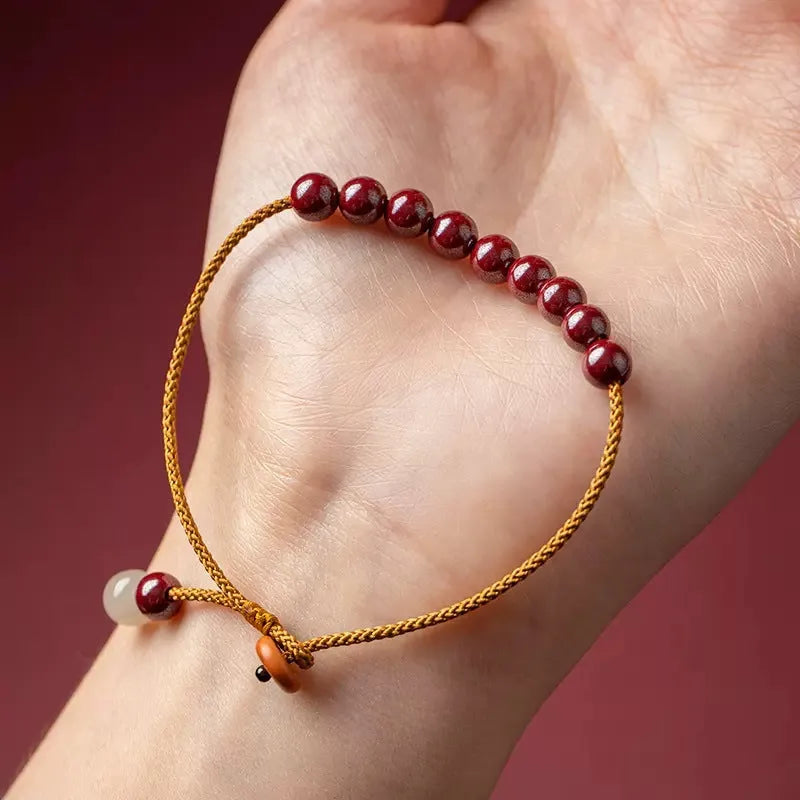 Hand-woven bracelet made from raw cinnabar and Hetian jade beads in a geometric design.