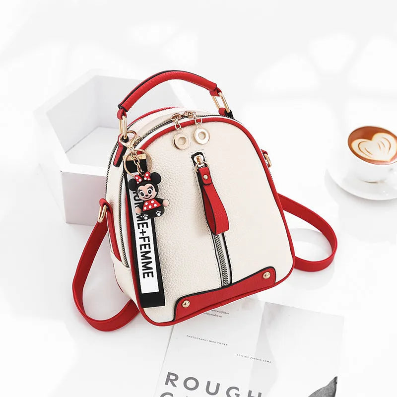 Women's PU leather oval fashion backpack with zip closure, multiple internal pockets and soft handle in white, red, black or pink