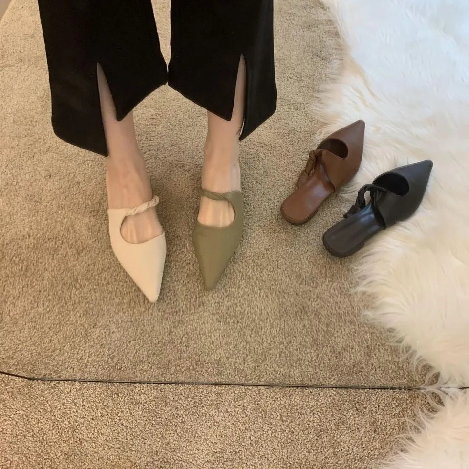 Women's soft leather semi-toe box slippers in black with a rubber sole, shown from the side.