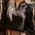 Black women's blouse with V-neck, contrast stitching, and three-quarter length ruffle sleeves