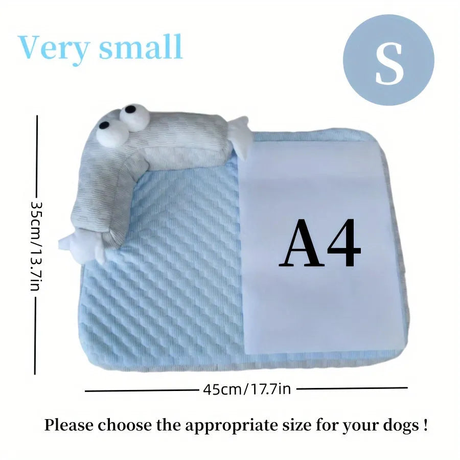 Blue pet bed cushion with big-eyed monster design on a wooden floor.