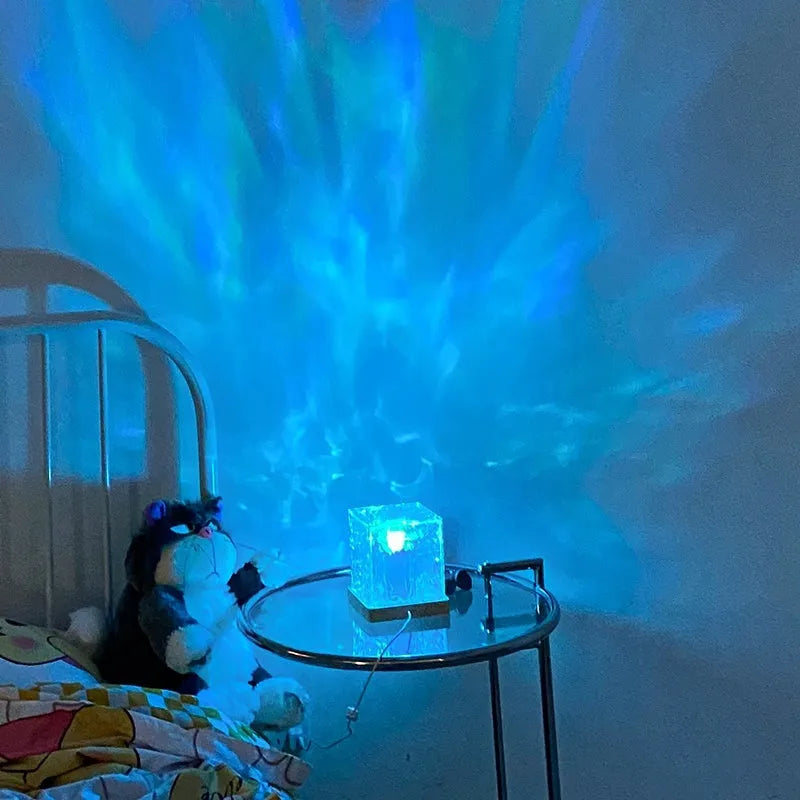 USB rechargeable LED water ripple night light with remote control on a table.