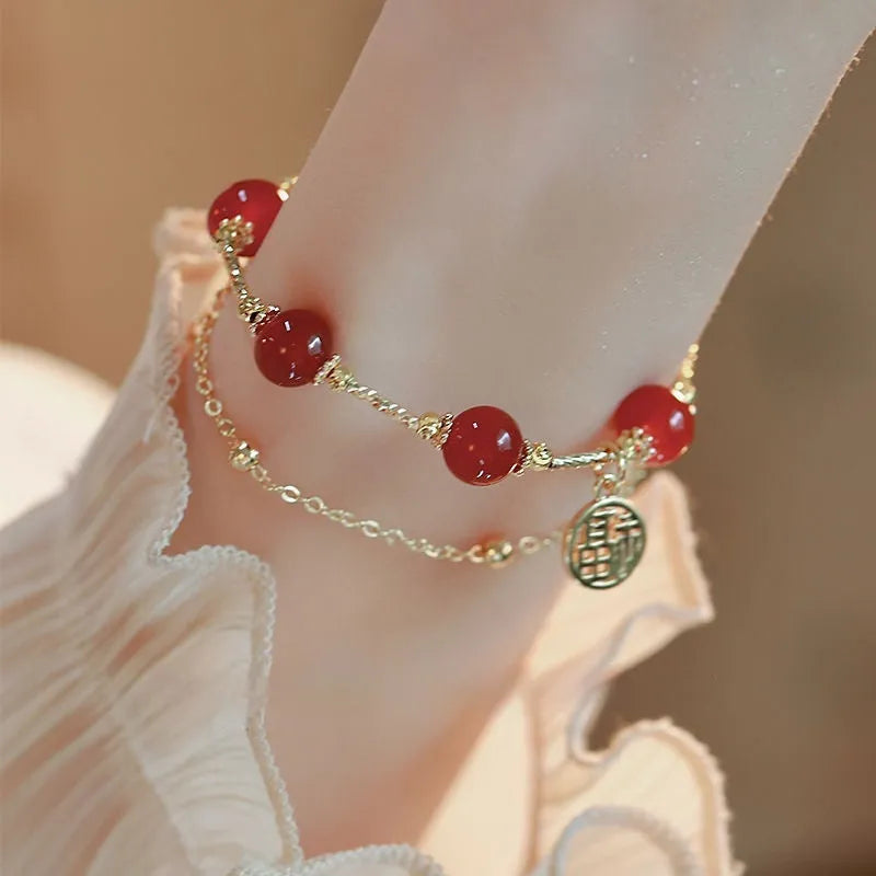 Close-up of a double-layer women's bracelet with a red agate blessing card and a red horse charm on an alloy band.