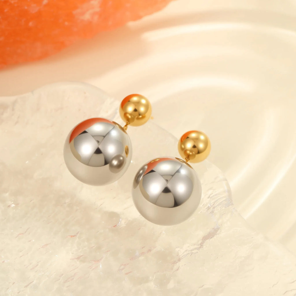 A pair of women's stud earrings with colour-blocked round geometric beads on stainless steel posts.