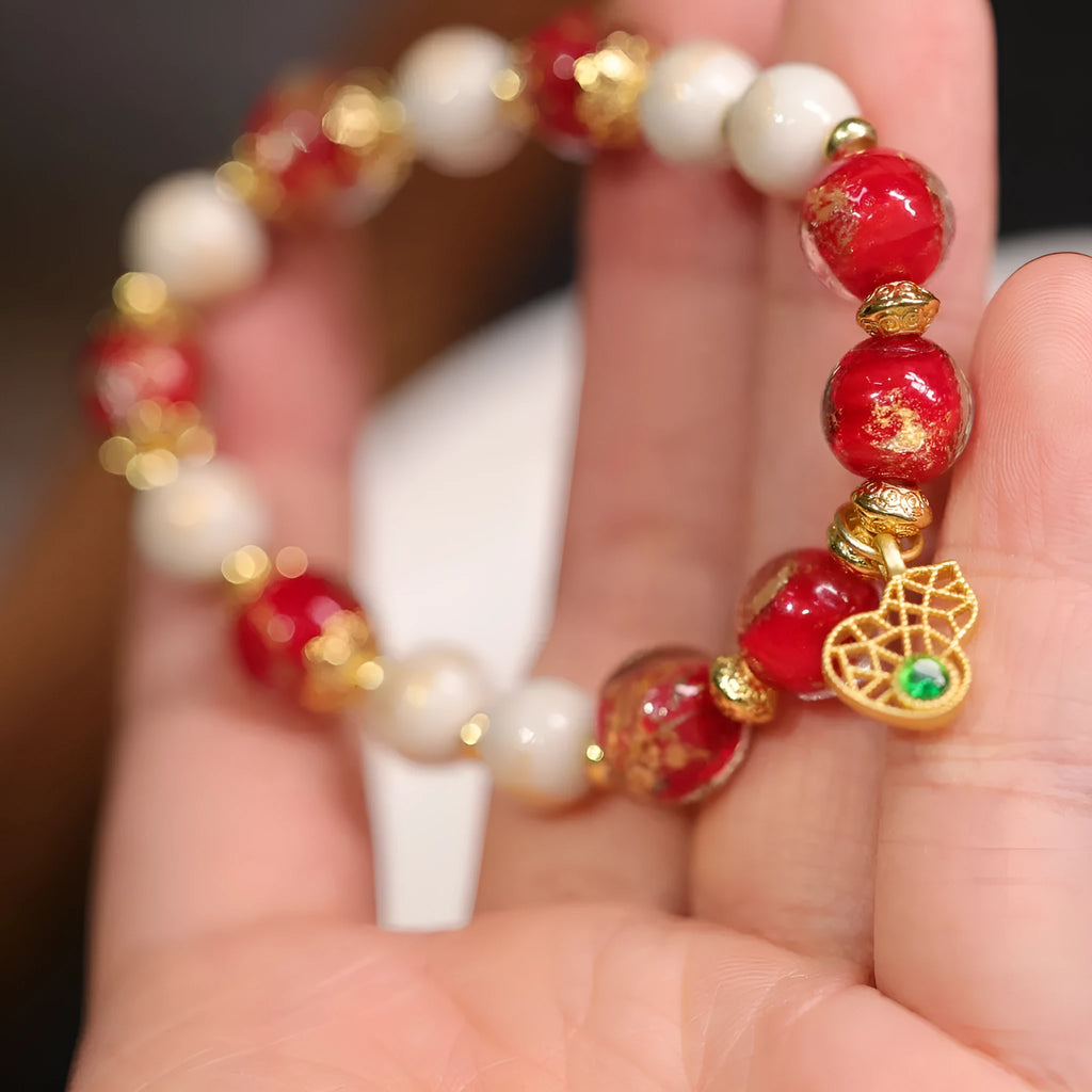 Gold foil coloured glaze ethnic bracelet with geometric design and God of Wealth pearl or porcelain hanging gourd