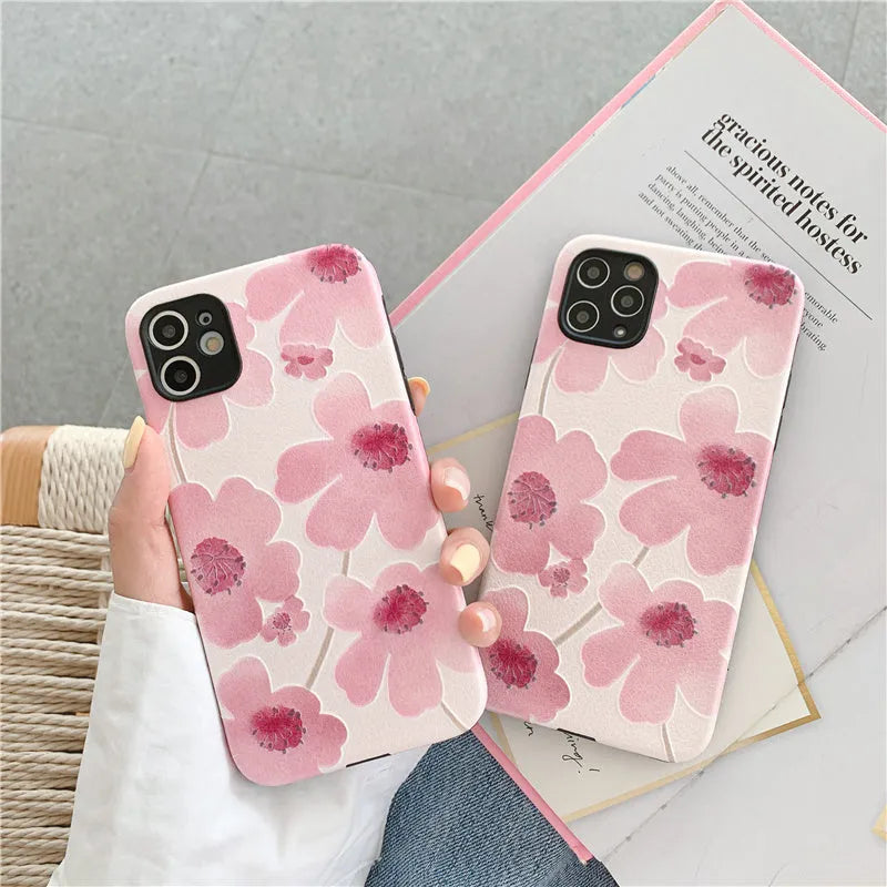 Pink soft rubber flower phone case for iPhone models on a flat surface, showing lanyard hole.