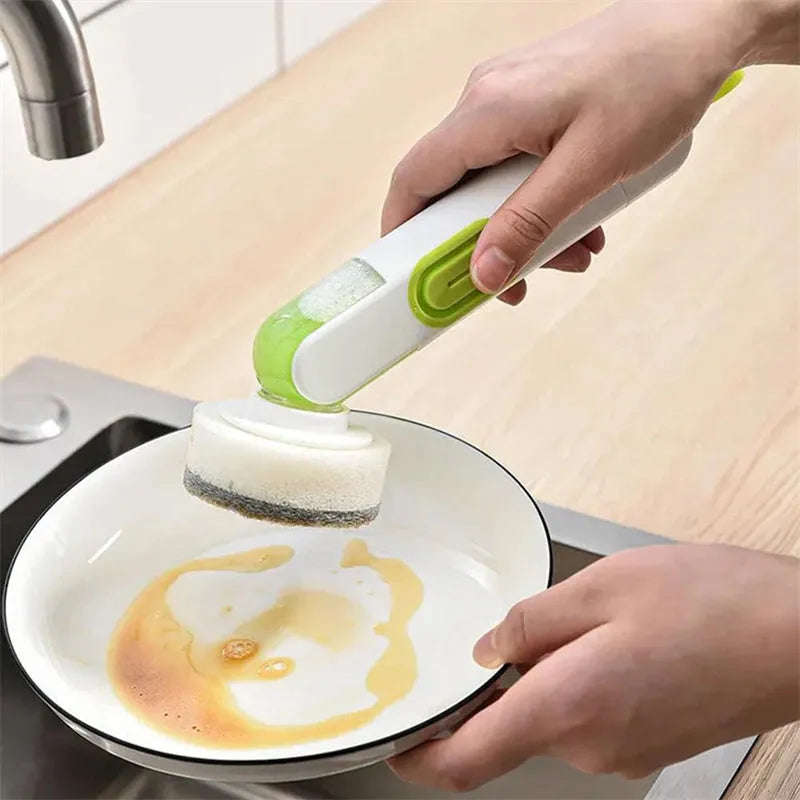 Long-handle kitchen cleaning brush with integrated soap dispenser and two removable brush heads, in white and red colour option.