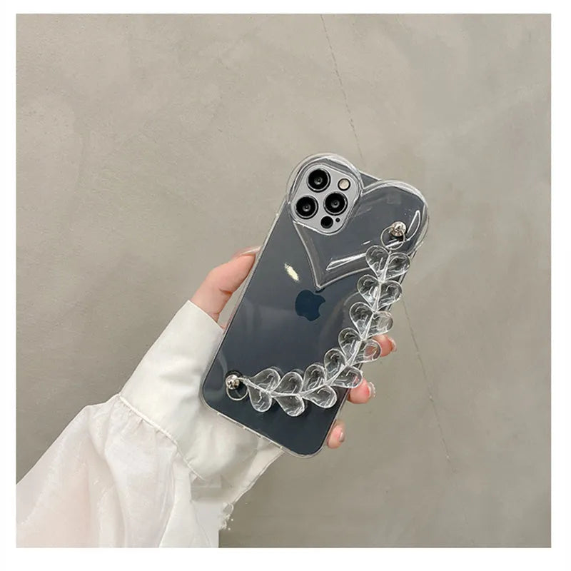 Transparent iPhone case with a soft TPU build and an integrated love heart chain, shown on a phone.