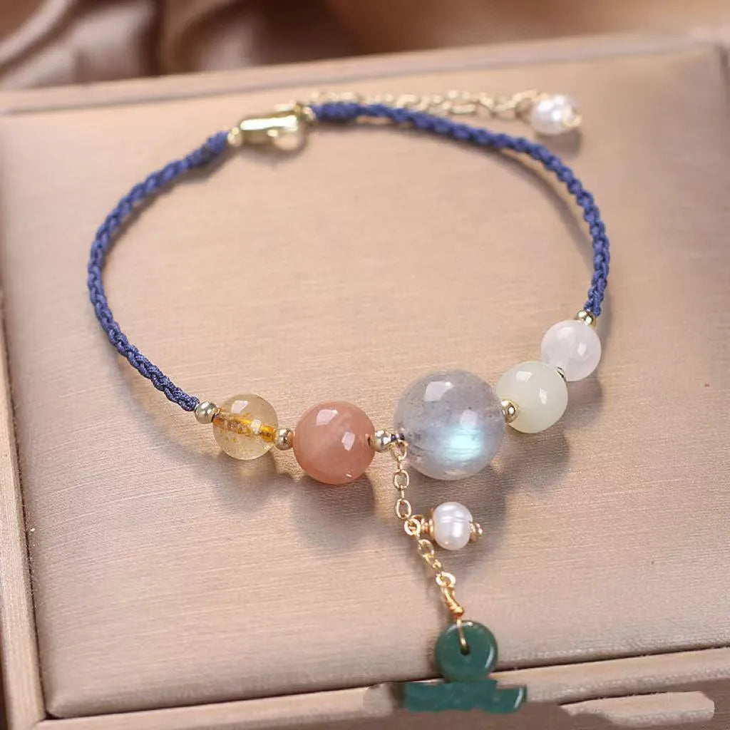 Women's hand-woven crystal and sequin bracelet with a silver peace buckle fastening on a wrist.