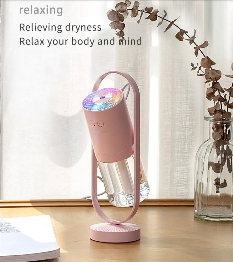 Pink USB portable air humidifier with projection night light on a wooden desk