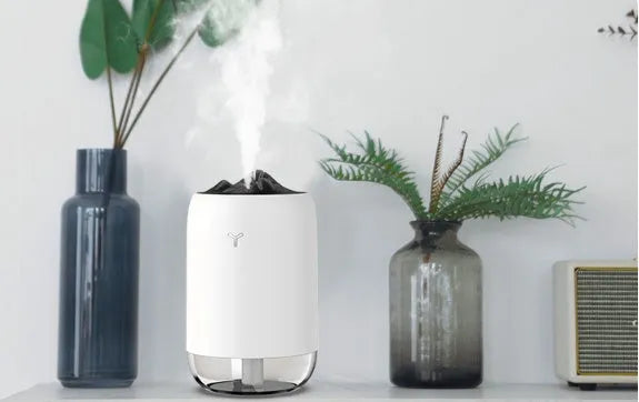 Mini cylindrical USB humidifier with night light in green, showing mist output and USB cable.
