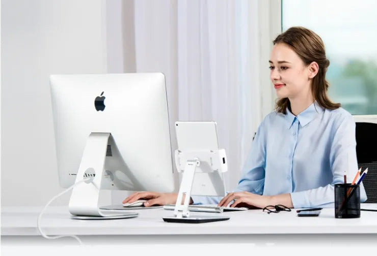 Silver foldable desktop holder supporting tablet with 360° rotation mechanism visible