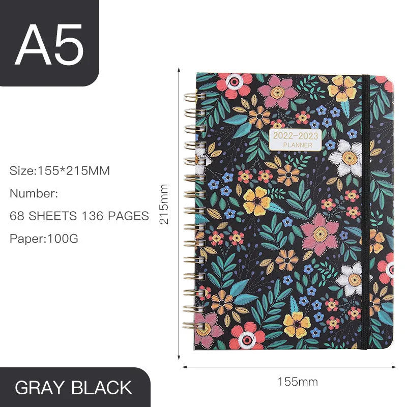 A5 spiral notebook with floral cover design, open to show 100g paper and spiral binding