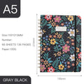 A5 spiral notebook with floral cover design, open to show 100g paper and spiral binding