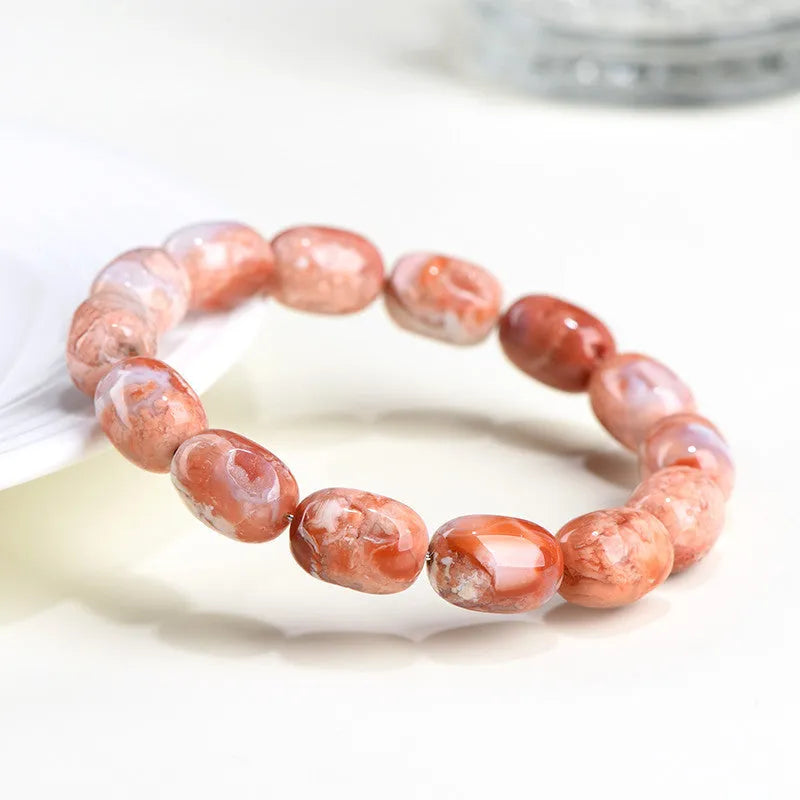 Natural cherry agate barrel shaped bead bracelet showing 10x14mm geometry design with Ruyi elements on wrist