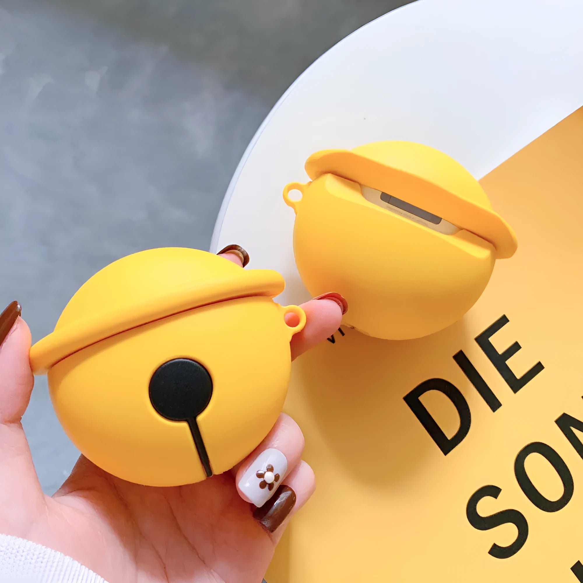 Yellow bell-shaped silicone protective case for AirPods 1st and 2nd generation with a keyring hole.