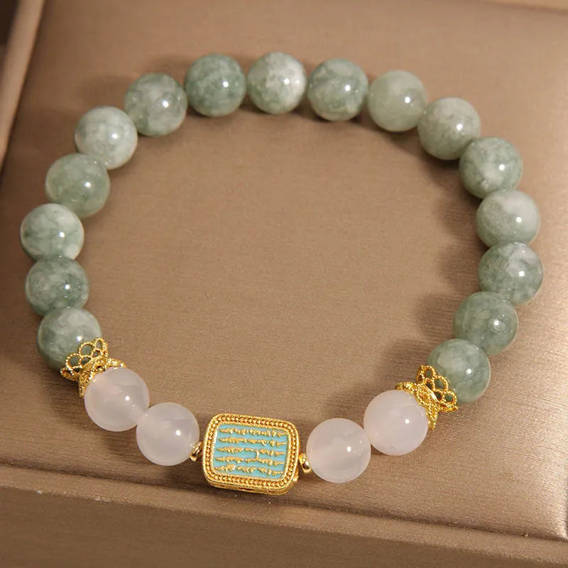 Natural oil green emerald crystal bracelet with five beads on a black elastic cord.