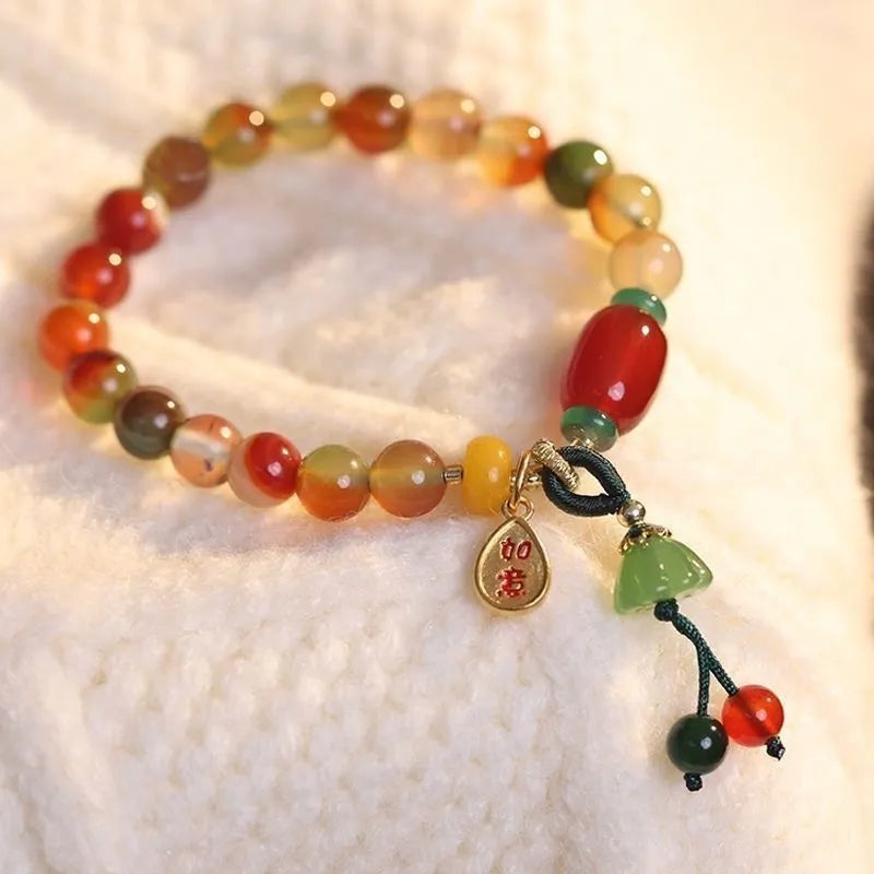 Handmade adjustable bracelet with a detailed lotus charm on a mixed material band.