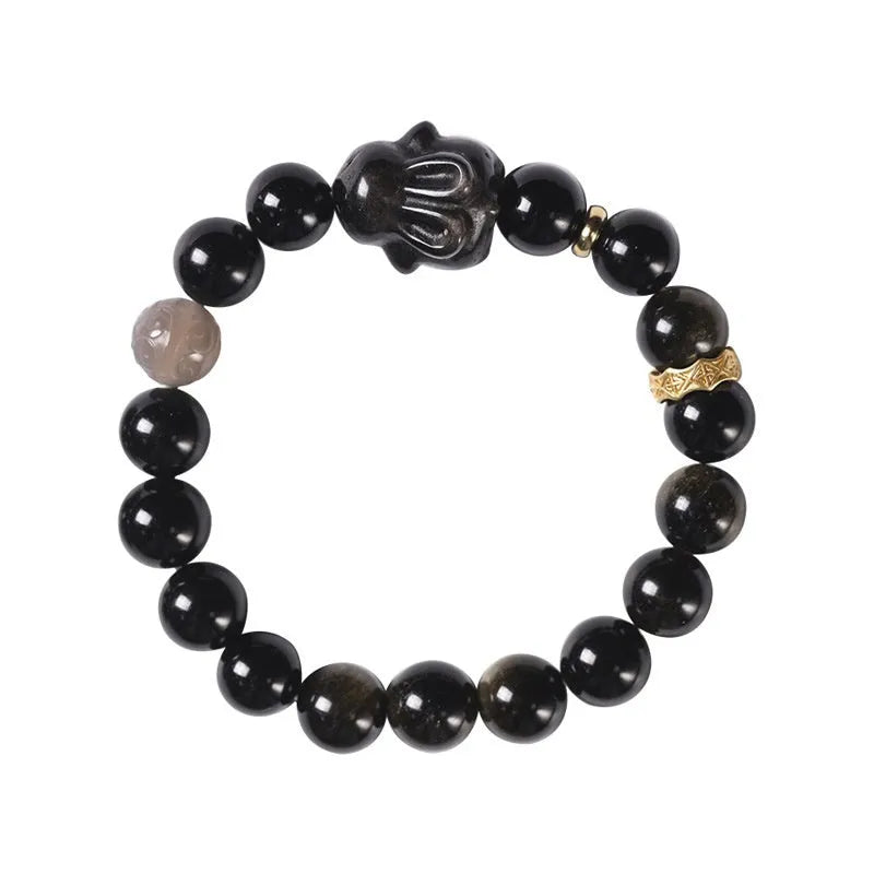 Handmade grey obsidian lying rabbit bracelet with brass and silver details on a wrist, shown in 8mm and 10mm size options.