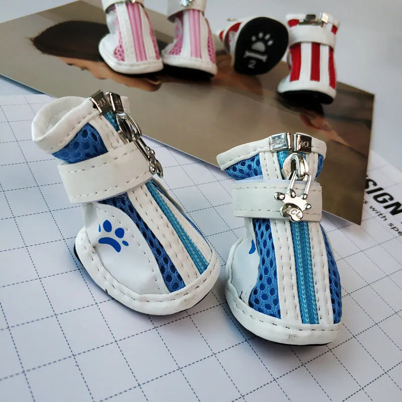Blue zip-up dog boot for small pet on a wooden floor.