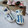 Blue zip-up dog boot for small pet on a wooden floor.