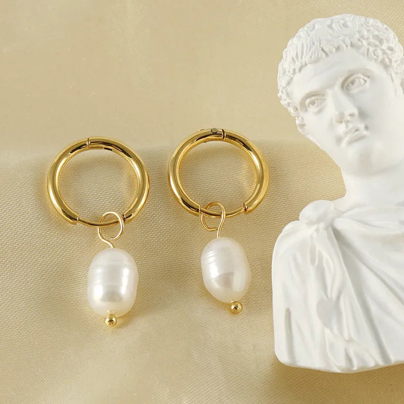 Gold geometric earrings with freshwater pearl accent on stainless steel background