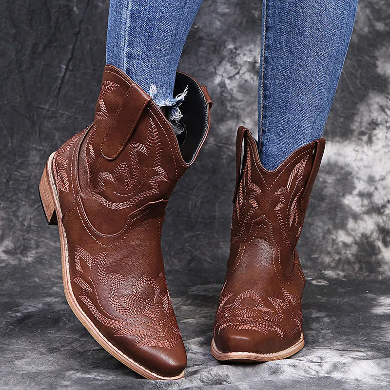 Women's blue cowboy boots with embroidery, wedge heel, and pointed toe on a neutral background