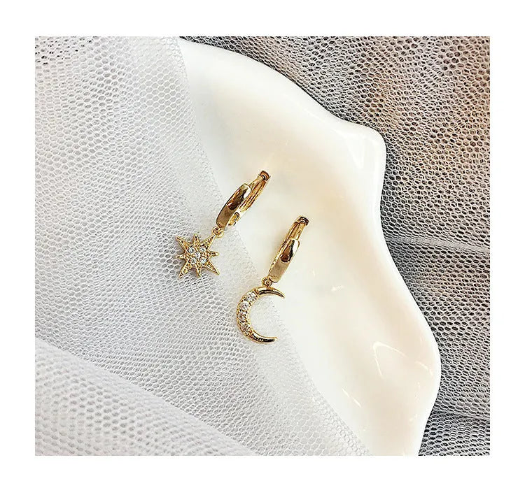 Pair of star moon pendant earrings in copper alloy with crystal detailing, shown in gold and silver options