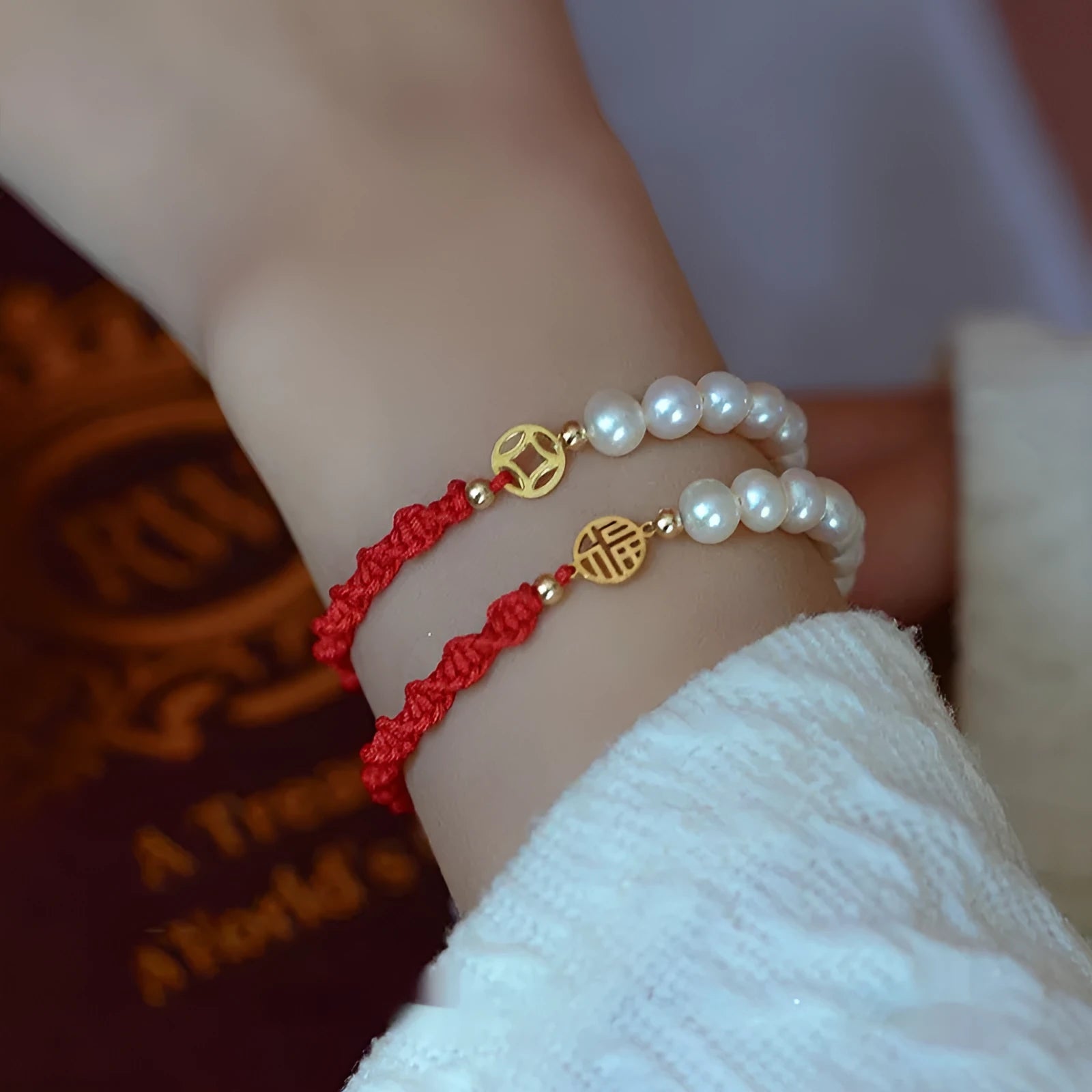 Women's pearl bracelet with braided red rope and gold plated fu character charm