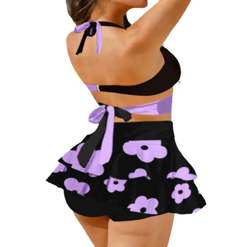 Women's purple bikini swimsuit with high-waisted briefs, backless design, lace-up top, and matching skirt for swimming.