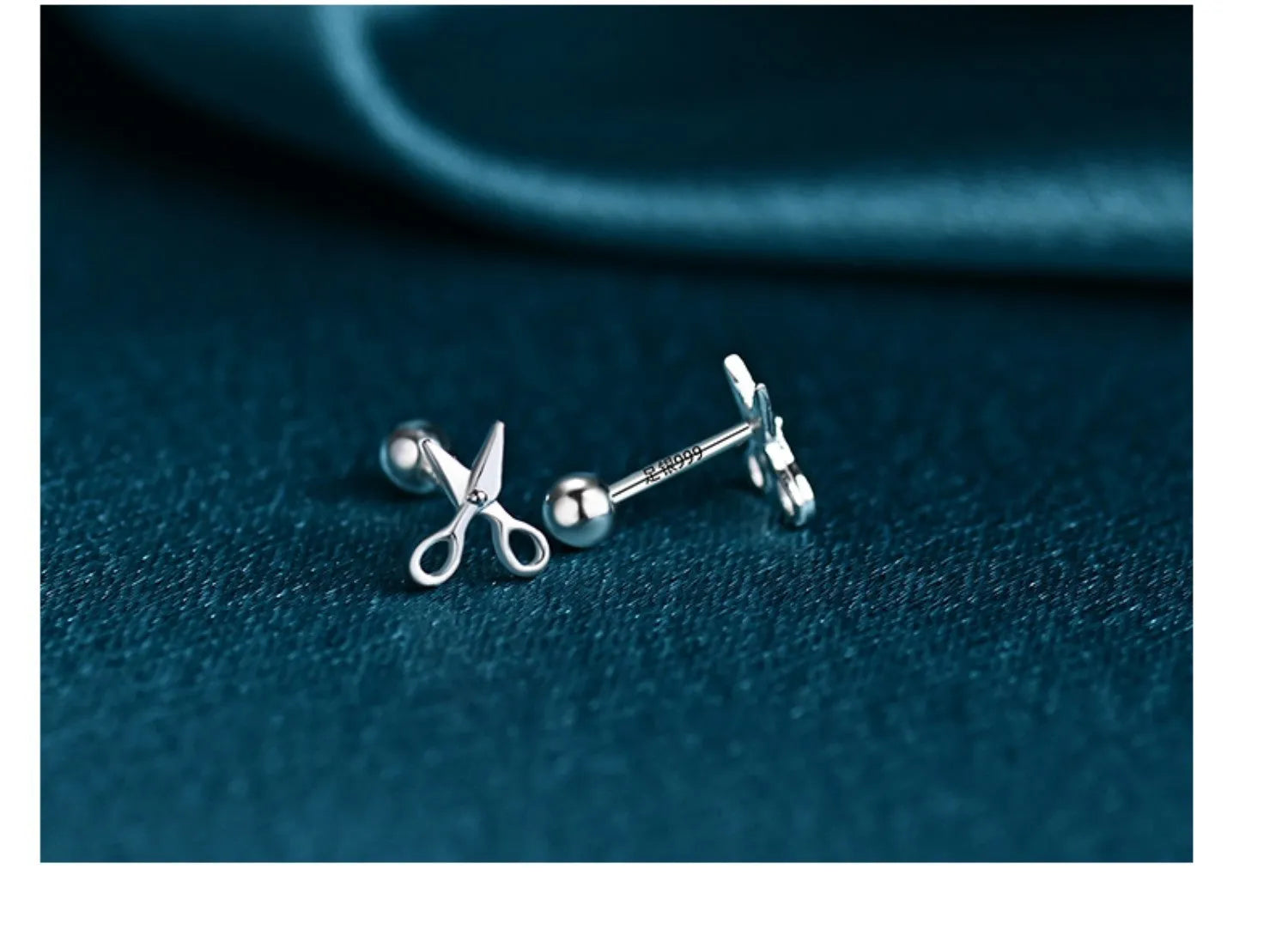 A pair of S999 pure silver earrings with screw-style closure shaped like miniature scissors.