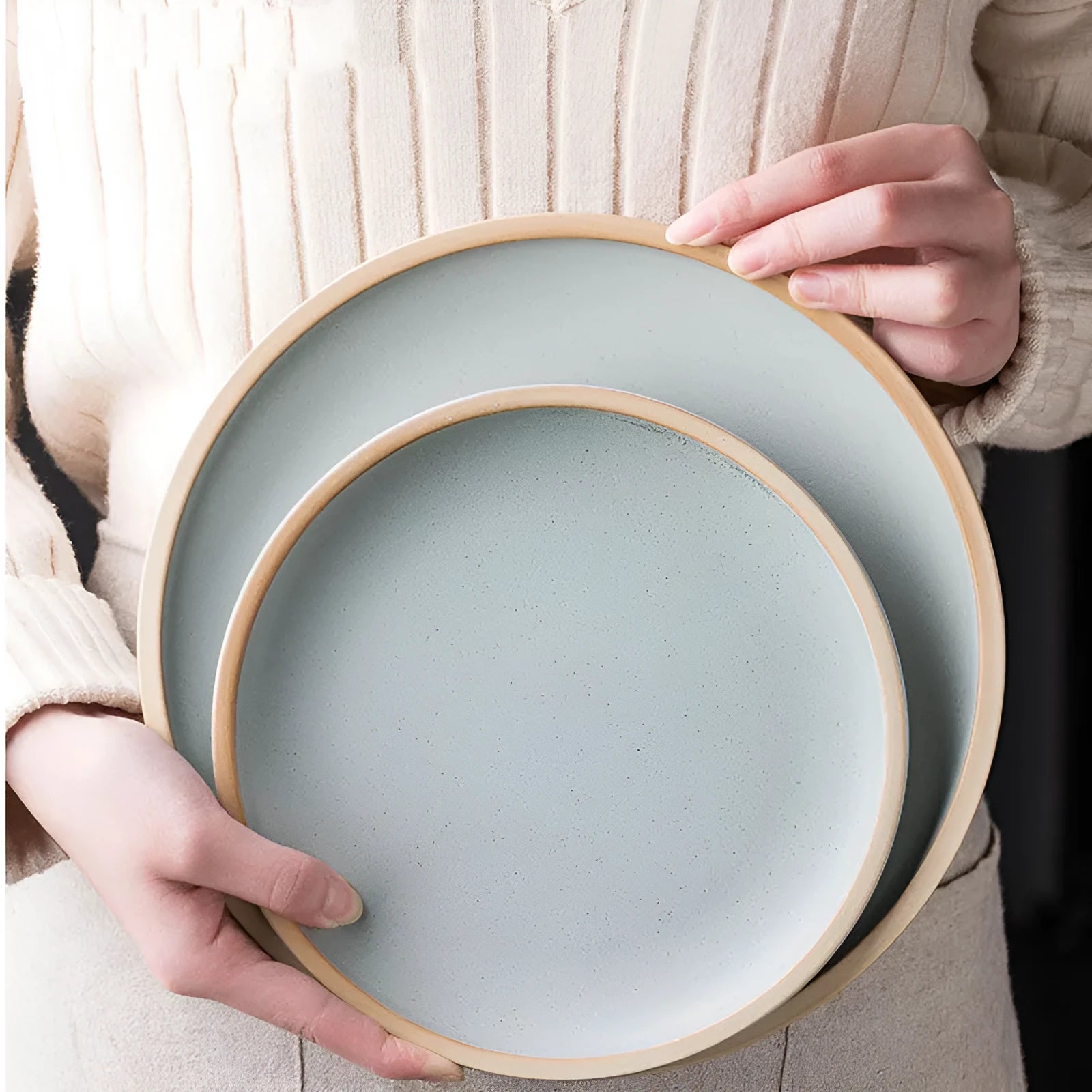 A 10-inch diameter pure blue matte ceramic dinner plate with a subtle textured finish on a wooden table.