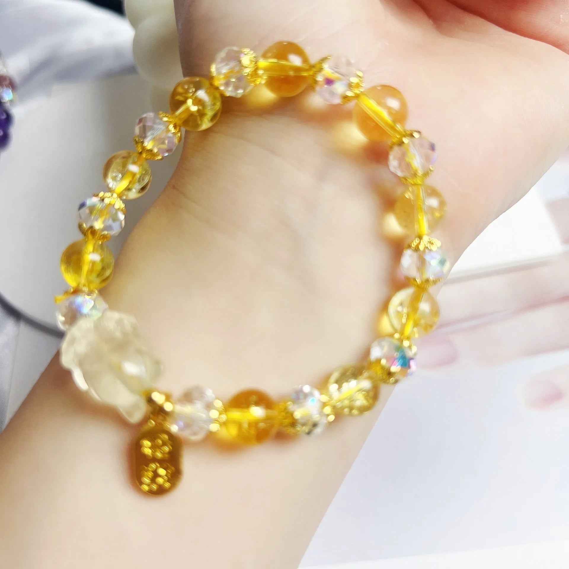 Close-up of an adjustable natural citrine crystal bracelet featuring a handcrafted nine-tail fox design on a white background.