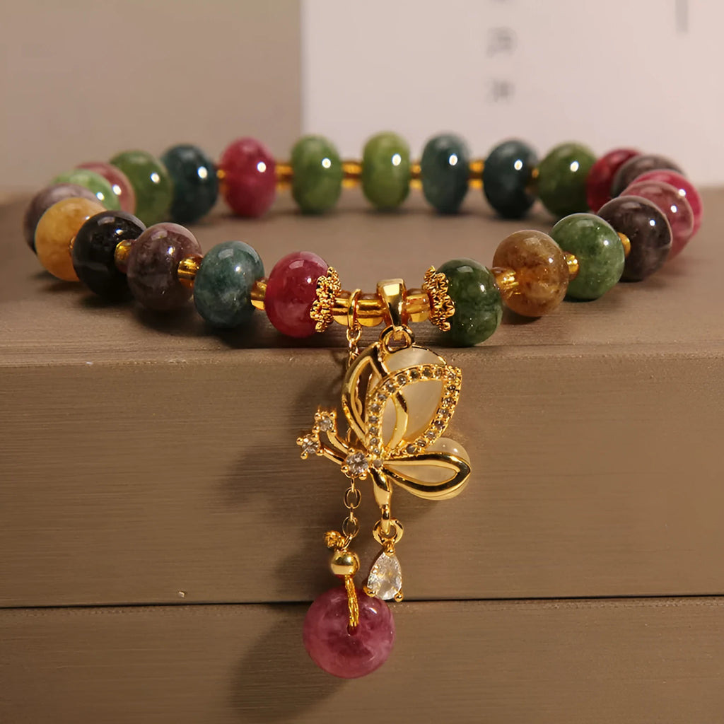 Colourful women's alloy bracelet with multicoloured beads and a butterfly charm on a wrist.