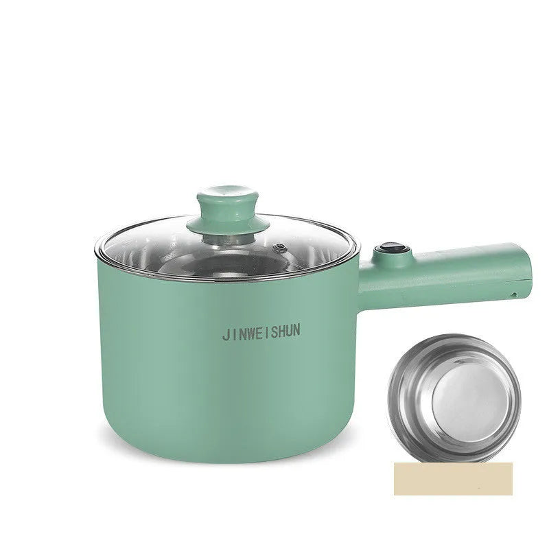 White and green mini electric hot pot cooker with stainless steel body and cooking accessories on a kitchen counter.