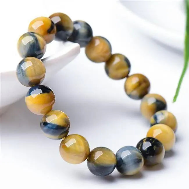 Handmade fantasy tiger eye agate beaded bracelet with 10mm round beads on a wrist.