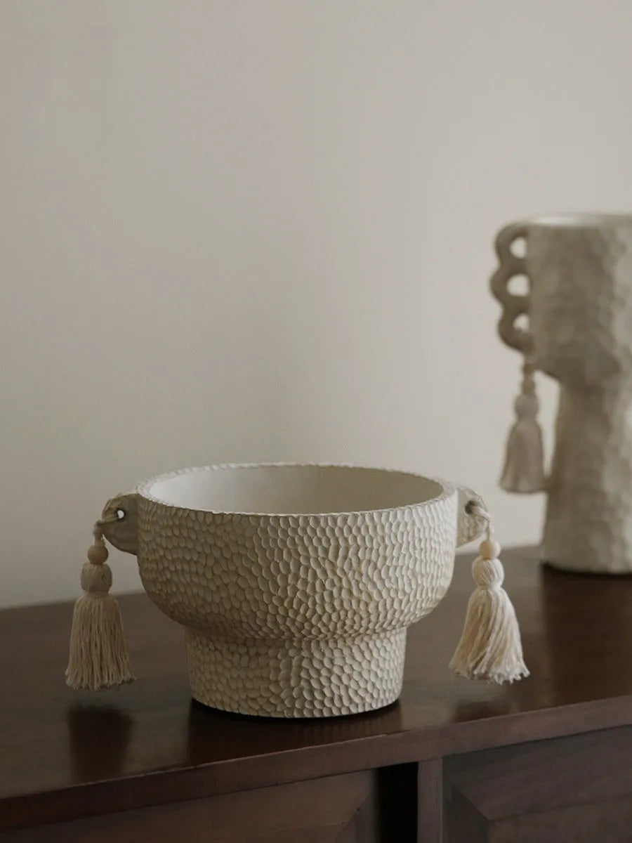 Ceramic binaural planter pot with decorative tassel flower motif on a white background.