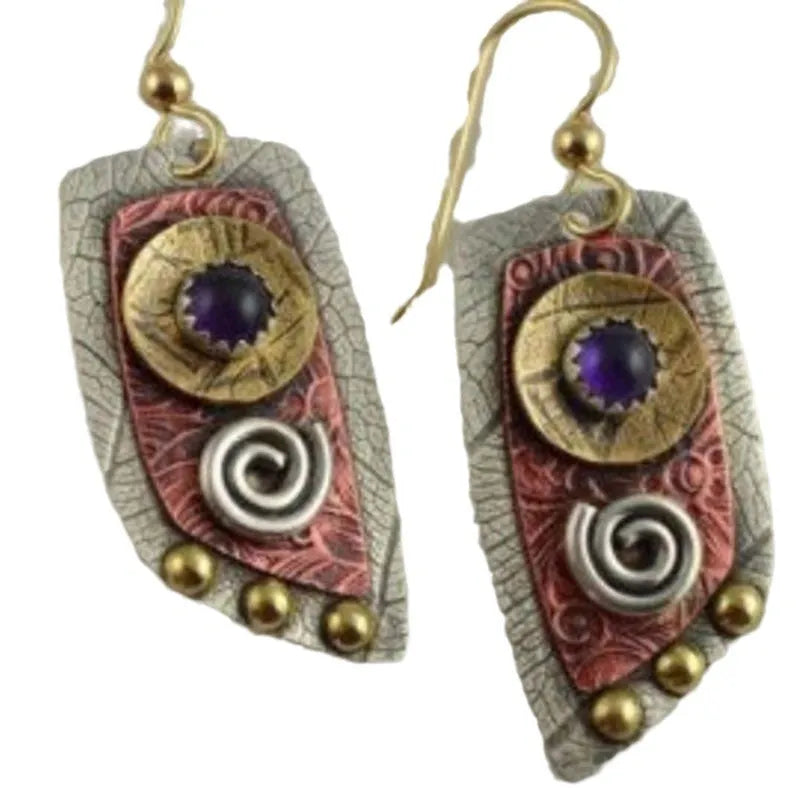 Gold-coloured metal earrings with camouflage leopard print and irregular geometric shapes on a white background