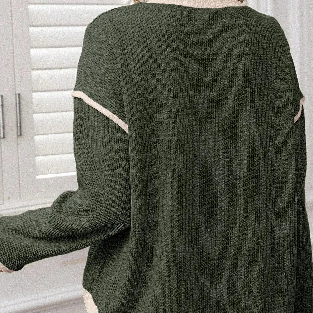 Beige loose drop shoulder knit top with green four-leaf clover design and contrast trim on neckline.