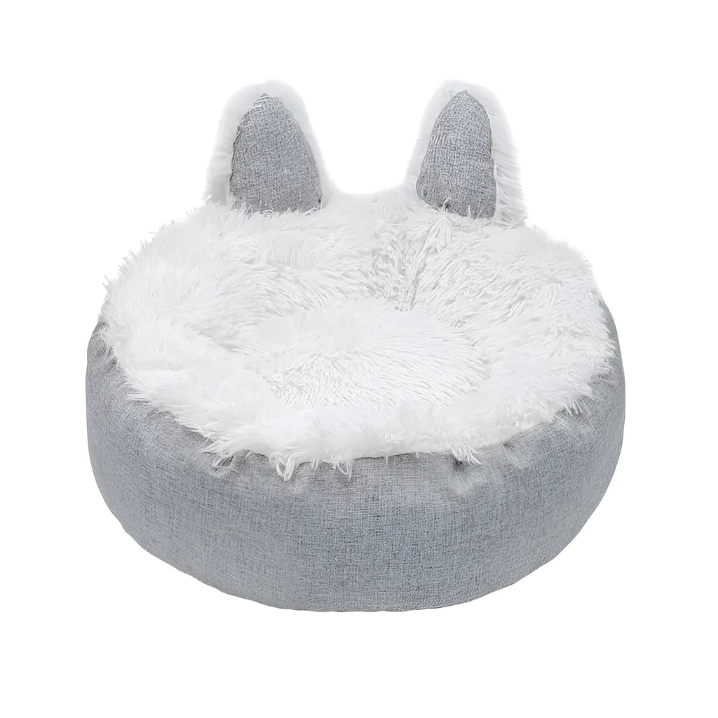 A round soft grey faux fur plush pet bed for cats or small dogs on a wooden floor.