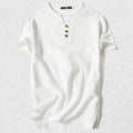 Man wearing a loose apricot coloured cotton linen blend t-shirt, showing the relaxed short sleeve pullover style.