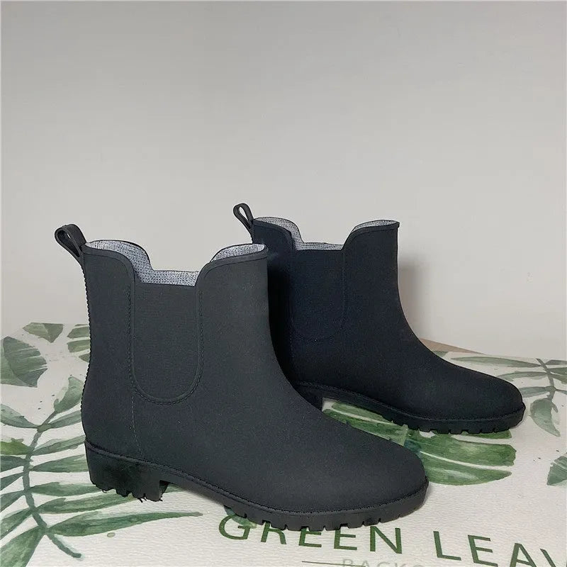 Pair of short rain boots in pink, milky white, or black with non-slip sole and mid-calf length