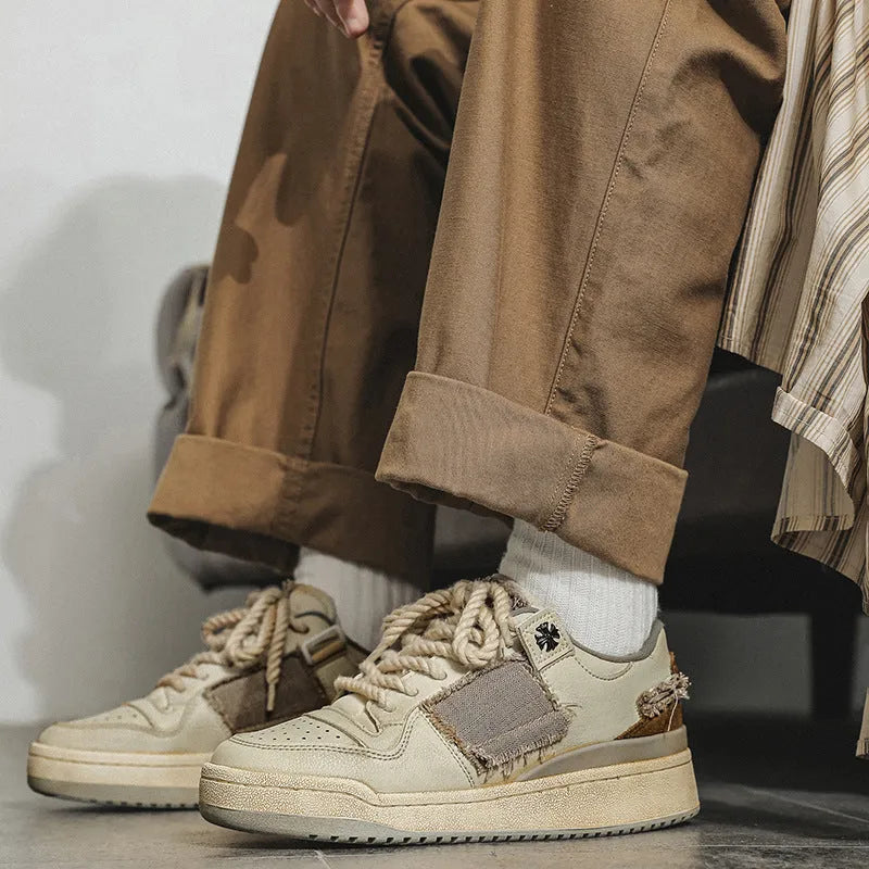 Beige low-top skateboard shoes with microfiber uppers, round toe, and lace-up closure on solid background