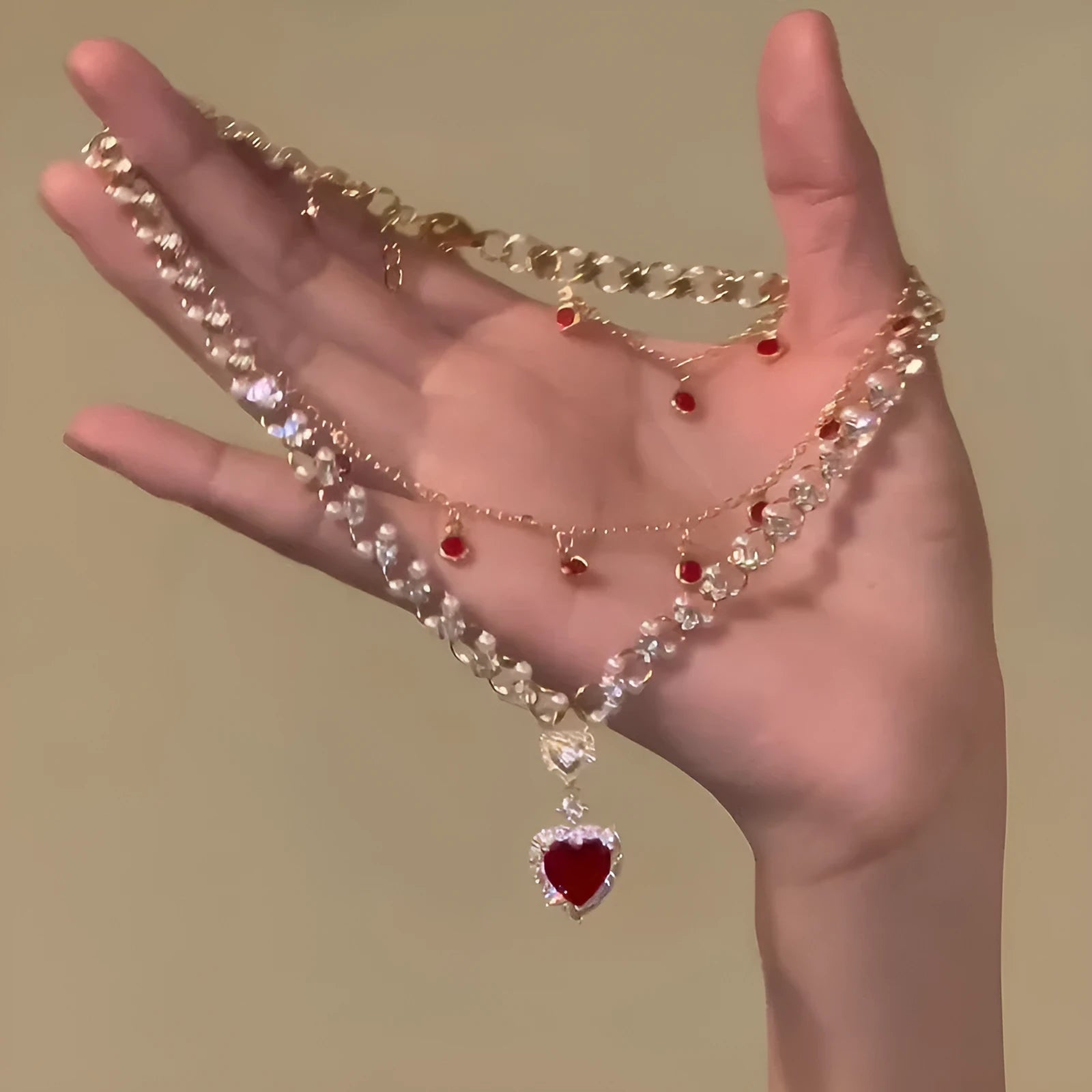 Red double layer necklace with two chains, a heart pendant, and an adjustable clasp.
