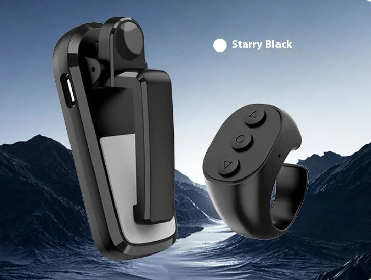 Black wireless page turner remote control and a small clicker on a wooden table.