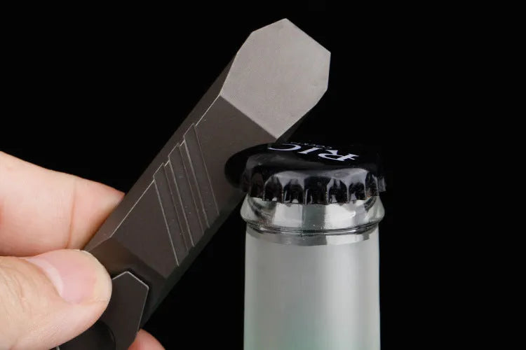 Titanium multi-function crowbar tool with screwdriver tip and bottle opener, shown in stone wash and gun grey finishes.