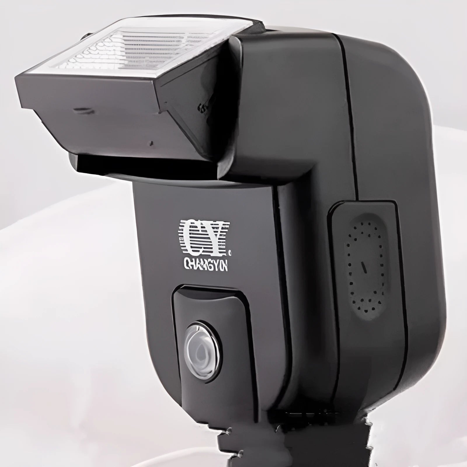 Compact silver SLR camera flash with tilted head mounted on a camera hot shoe