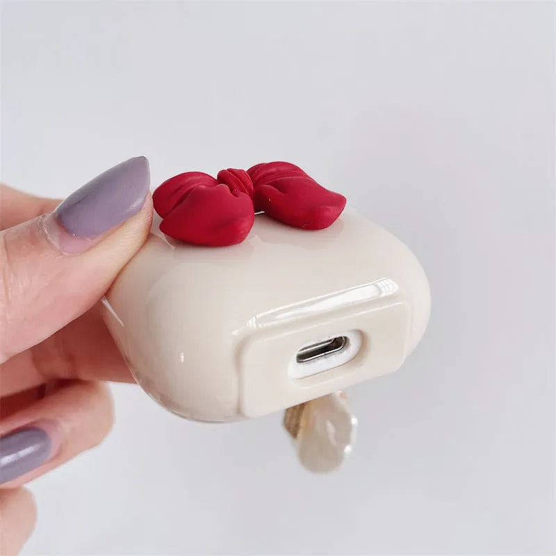 Beige TPU clamshell earphone case with a red bow design for AirPods.
