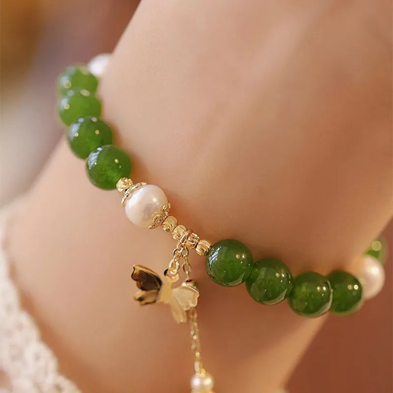 Green chalcedony bracelet with geometric round beads on a wrist.